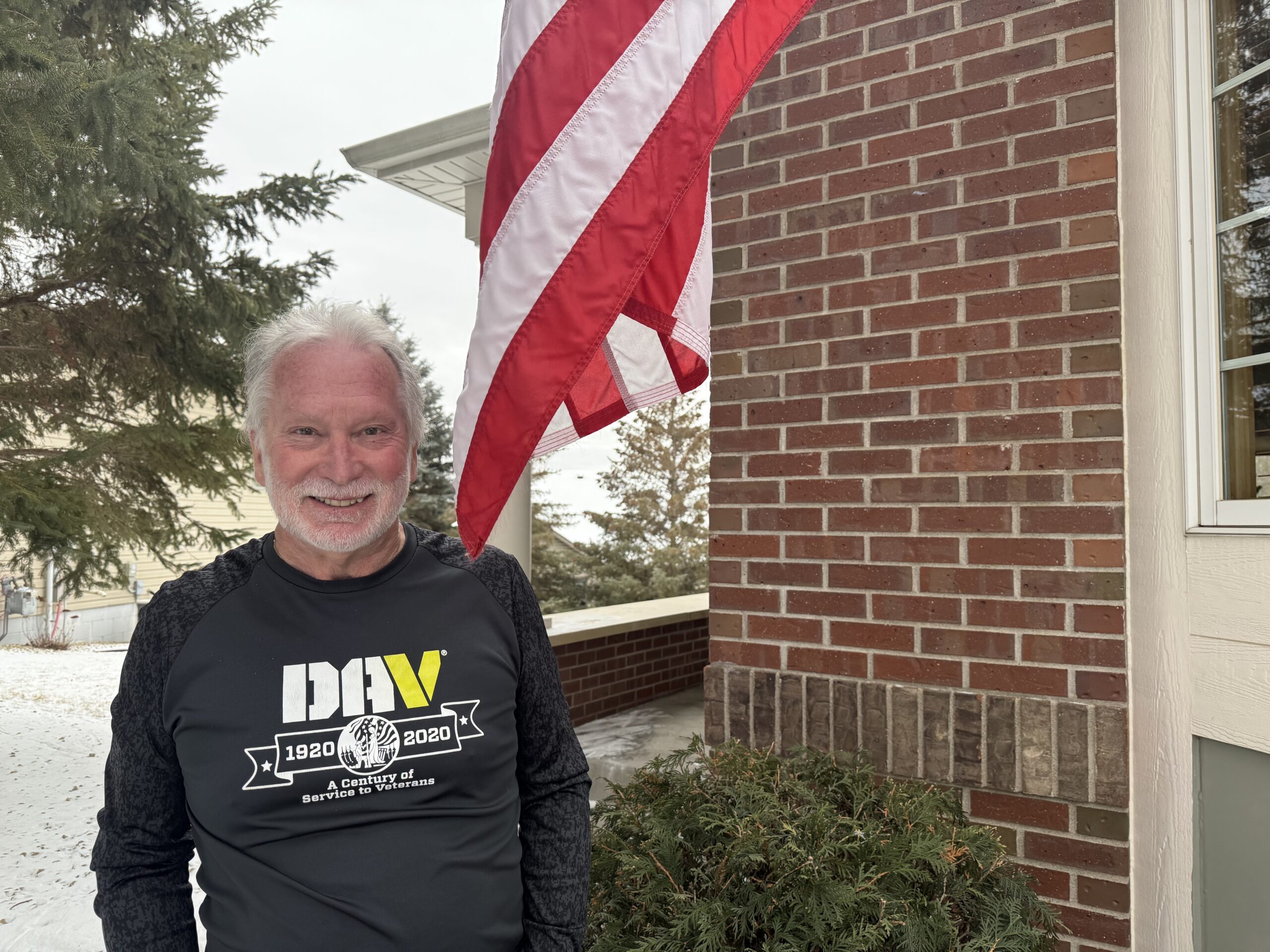 Casey Mahon in front of his home and American flag.